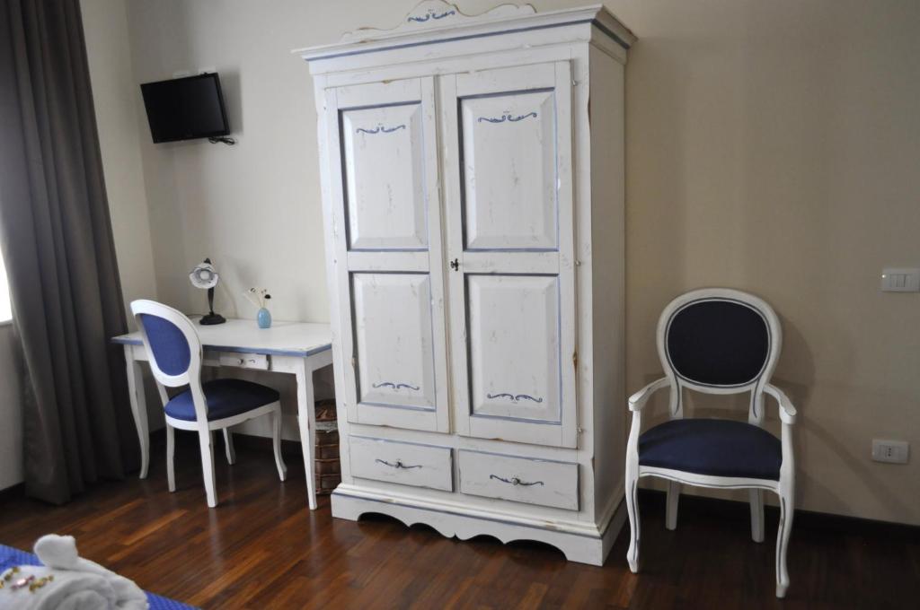 パレルモにあるStupor Mundi Bed and Breakfastの白いキャビネット、デスク、椅子が備わるベッドルーム1室が備わります。