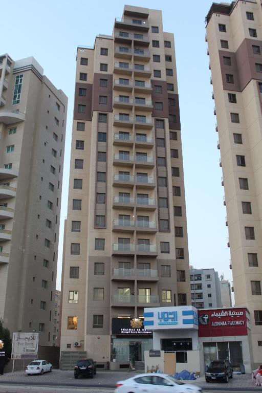 a tall building with cars parked in front of it at ماجيك سويت المهبولة 5 Magic Suite ALMahboula 5 in Kuwait