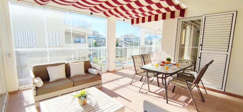 un soggiorno con tavolo e divano di Apartamento Los Mares by DENIA COSTA a Denia