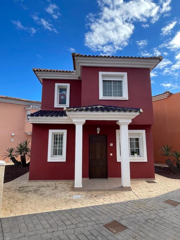 una casa roja con columnas blancas en Altaona Comfort & Calidad Villa, en Murcia