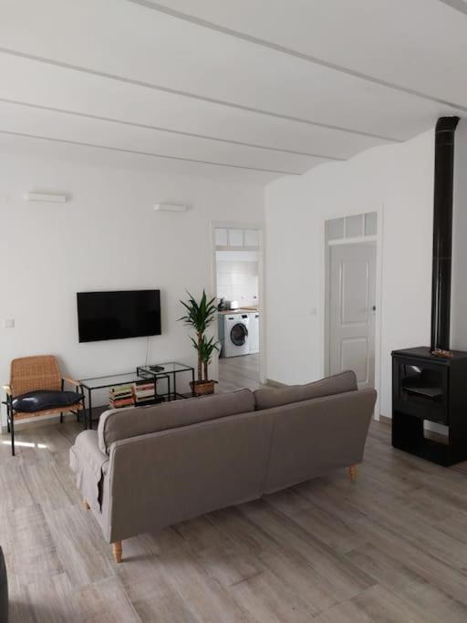 a living room with a couch and a flat screen tv at Casa Maria Inácia T2 in Évora