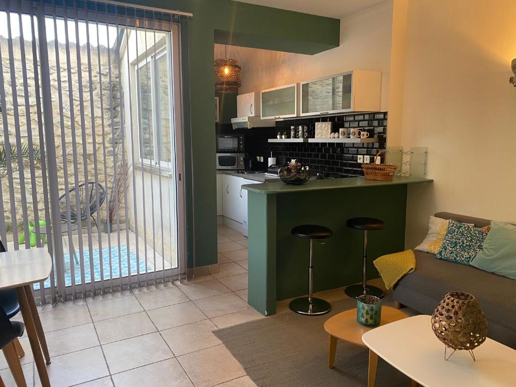 a living room with a couch and a kitchen at Le Loft PATIO, au coeur du village in Saint-Rémy-de-Provence