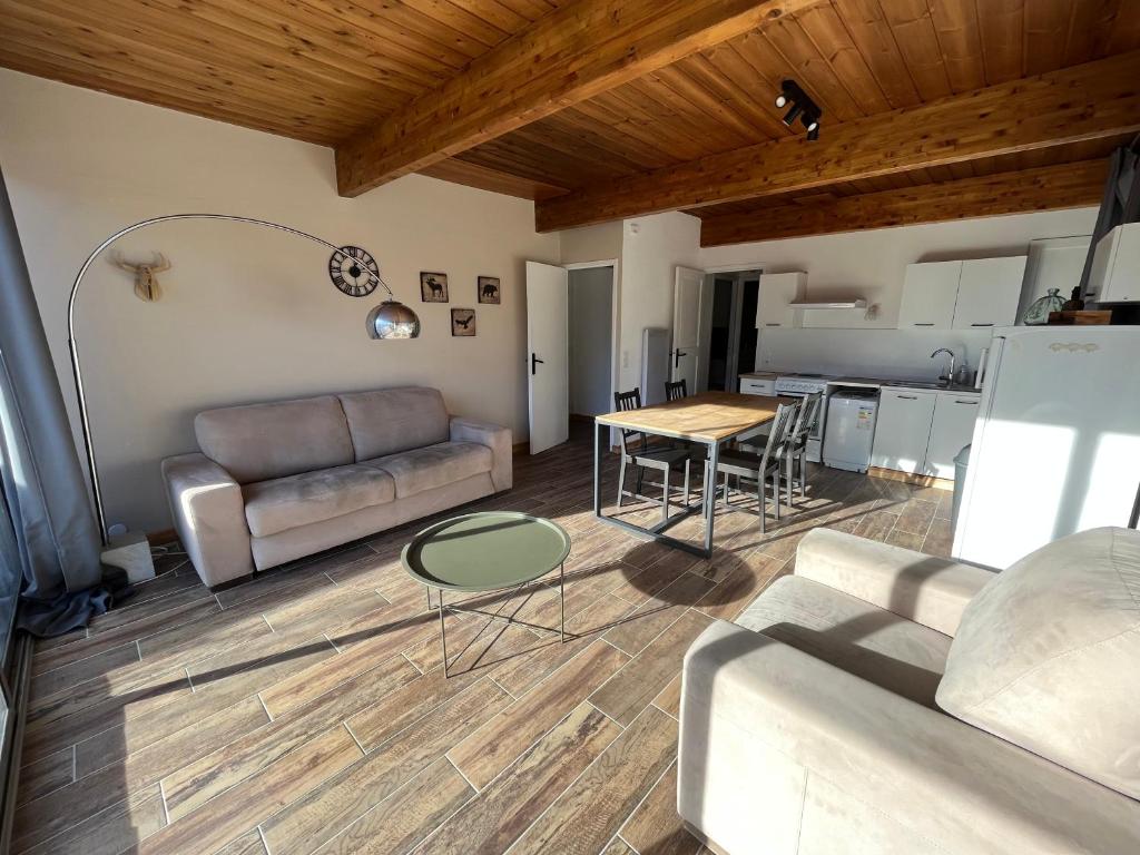 a living room with a couch and a table at Barcelonnette location avec jardin in Barcelonnette