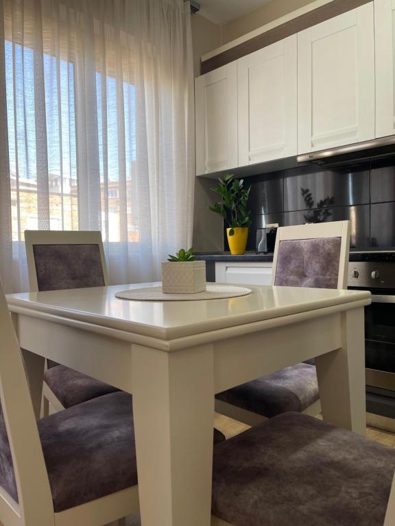 una mesa blanca en una cocina con 2 sillas en Tirana New Bazaar- Apartment no-1, en Tirana