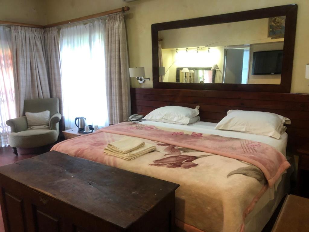 a bedroom with a large bed with a large mirror at A boutique lodge situated in a serene environment - 2024 in Harare