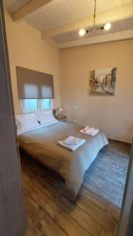 a bedroom with a large bed with two towels on it at Ria's GardenView apartment in Ioannina