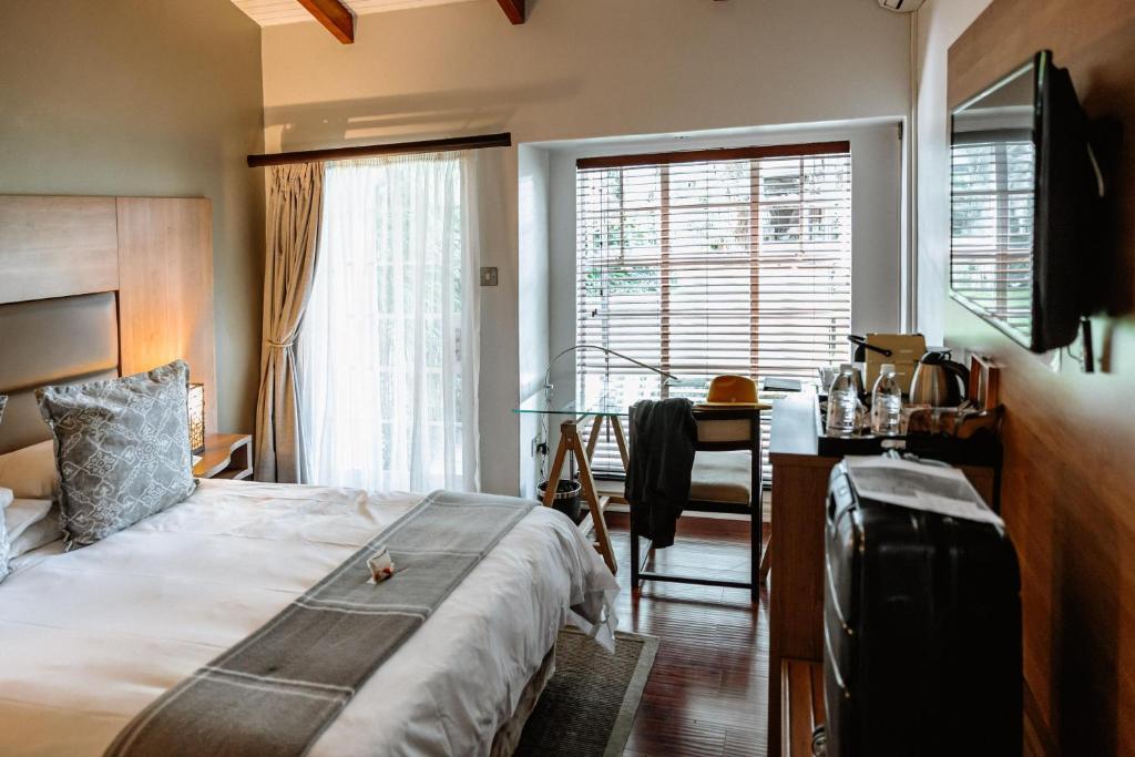 1 dormitorio con cama, escritorio y ventana en The 5 Stars Sandalwood Lodge in Mount Pleasant - 2020, en Kingsmead