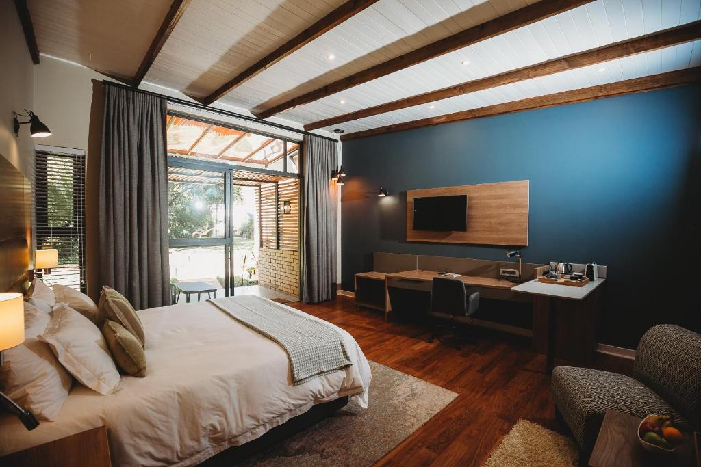 a bedroom with a bed and a desk and a television at 5 Stars Sandalwood Lodge is situated in Mount Pleasant - 2019 in Kingsmead