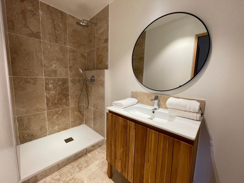 ein Badezimmer mit einem Waschbecken, einem Spiegel und einer Badewanne in der Unterkunft Gîte Les 27 in Saint-Denis-le-Ferment