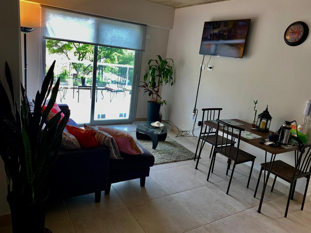 sala de estar con sofá, mesa y comedor en Balcon de Belgrano en Salta