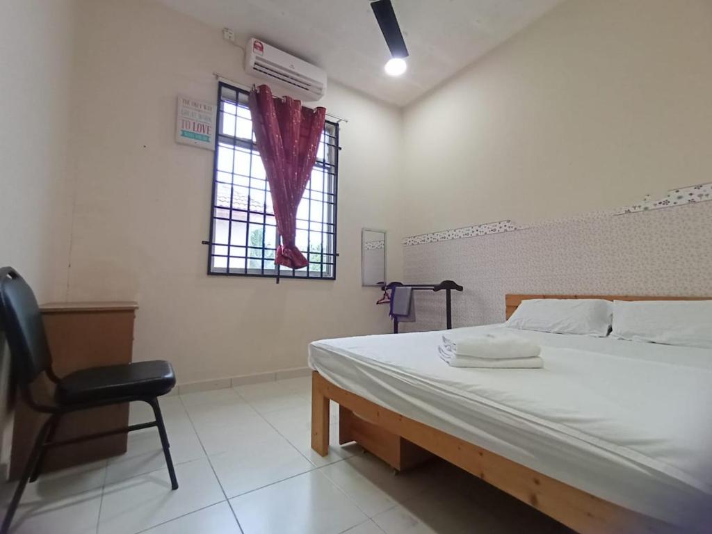 a bedroom with a bed and a chair and a window at Seaview Promenade Homestay Dungun in Dungun