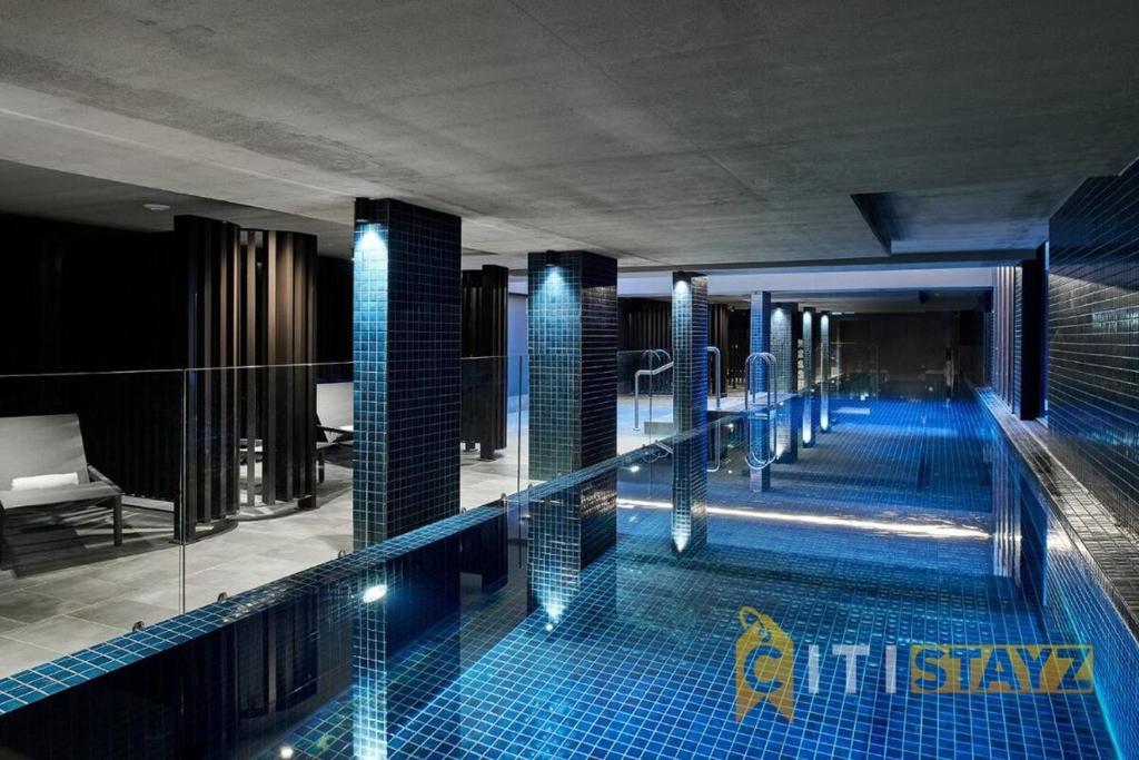 una gran piscina con azulejos azules en un edificio en Majestic at Midnight! Luxe 1 bd 1bth 1csp Apt, en Canberra