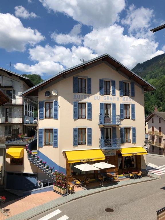 a hotel with yellow umbrellas and tables in front of it at Hôtel du Grand-Mont in Beaufort