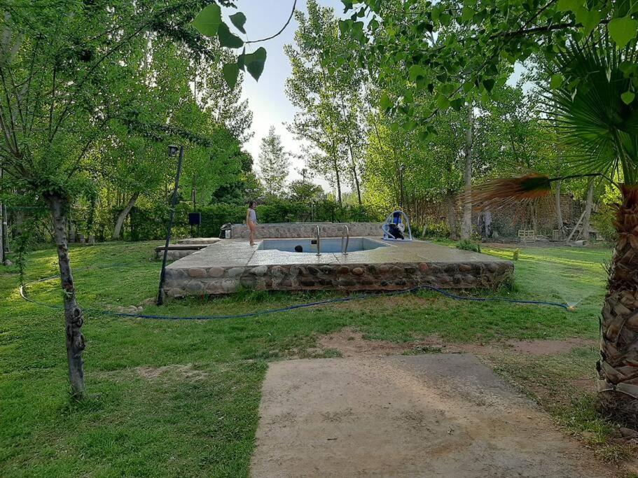 un hombre está parado en un parque con un estanque en Lujan de Cuyo Mendoza en Luján de Cuyo