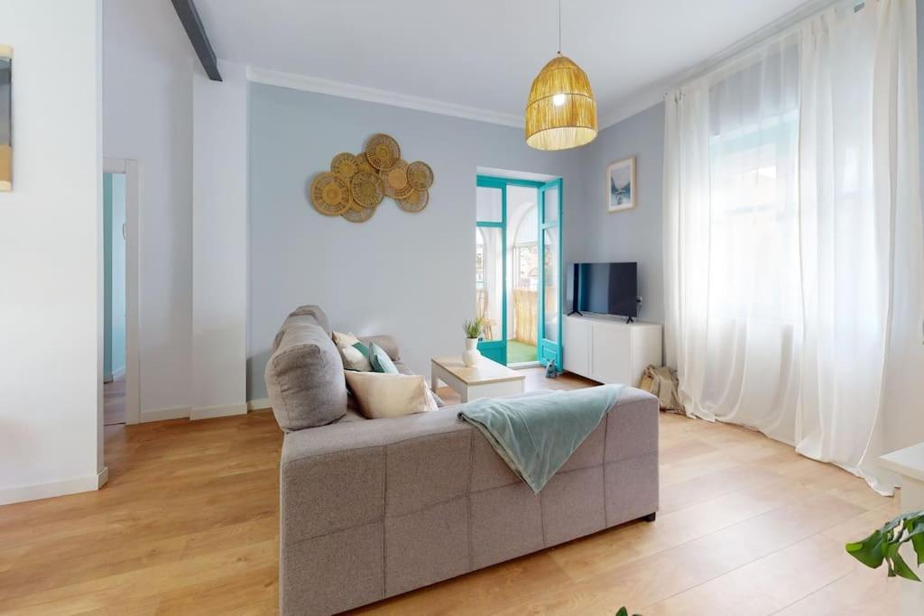 salon z kanapą i telewizorem w obiekcie Bright flat Rosaleda w Maladze