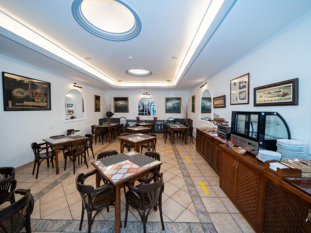 a restaurant with tables and chairs and a flat screen tv at Hotel Ida Inés in Frontera