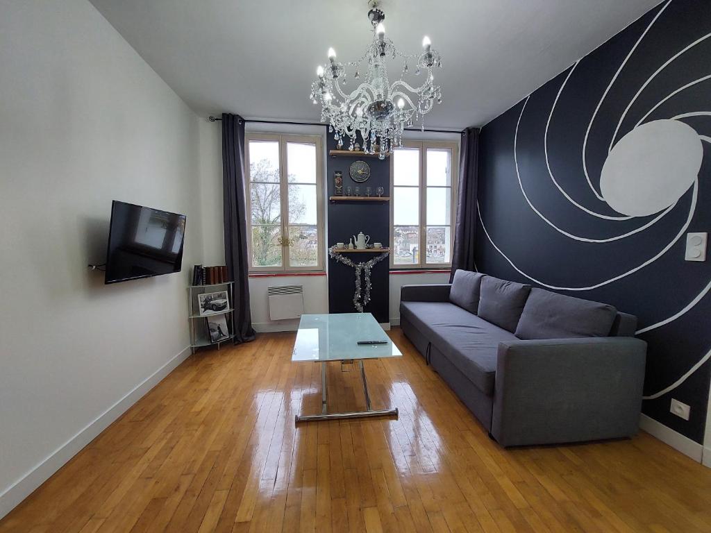 salon z kanapą i stołem w obiekcie Kilomètre 99 w mieście Pont-sur-Yonne