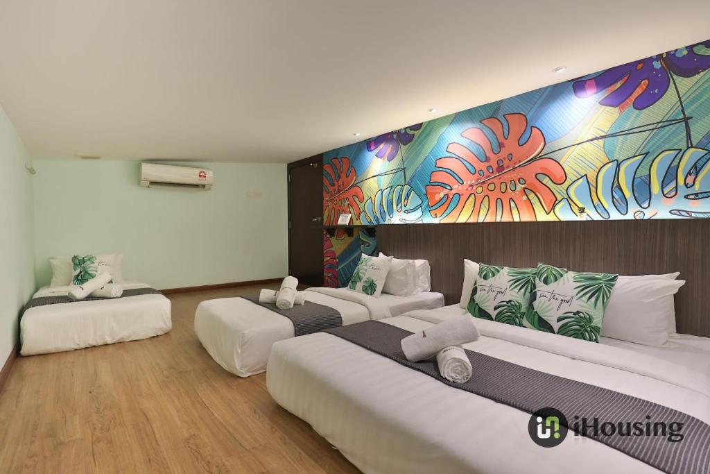 Habitación con 2 camas y una pintura en la pared. en Trevor Hotel Malacca Town By I Housing en Melaka