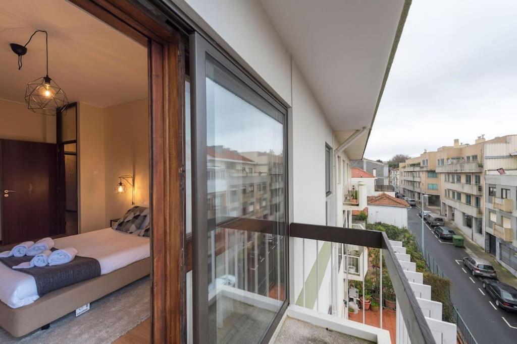 a room with a balcony with a bed and a window at Spacious apartment with parking at Serralves in Porto