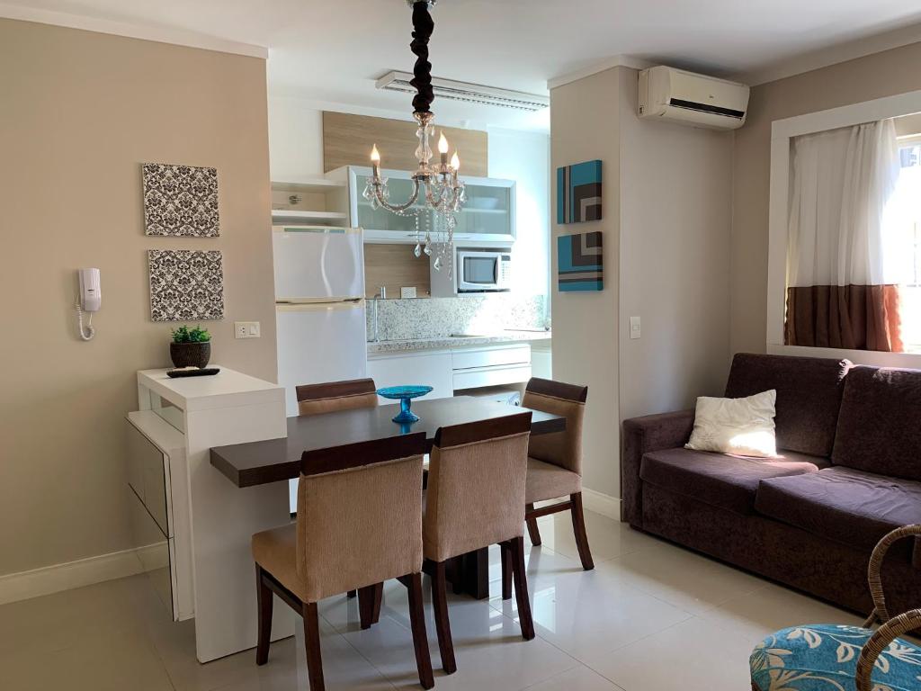 Una cocina y una sala de estar con una mesa y un sofá. en Apartamento Ilhas do Sul, en Balneário Camboriú