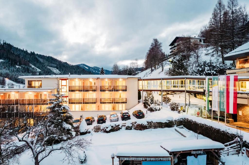 budynek w śniegu z zaparkowanymi samochodami w obiekcie Gesundheits- & Wellness Resort Oberzeiring w mieście Oberzeiring