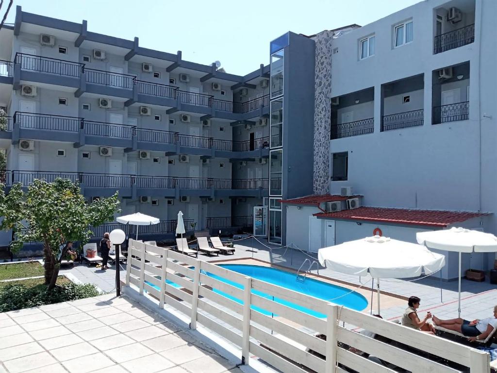 um hotel com piscina em frente a um edifício em Golden Beach Hotel em Metamorfosi
