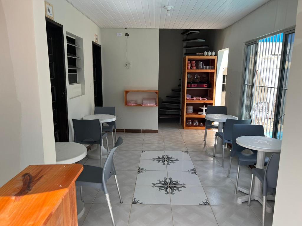 a dining room with tables and chairs and a tv at Pousada Mar do Sonho Praia in Ipojuca