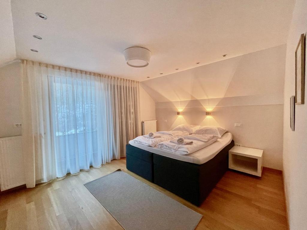 een slaapkamer met een groot bed voor een raam bij Ian's Residence in Kranjska Gora
