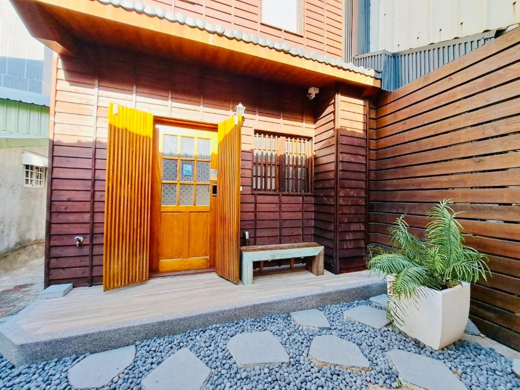 ein Haus mit einer Holztür und einer Bank in der Unterkunft 末廣通二館 日式包棟民宿Suehirodori Japanese Entire Homes No2 in Tainan