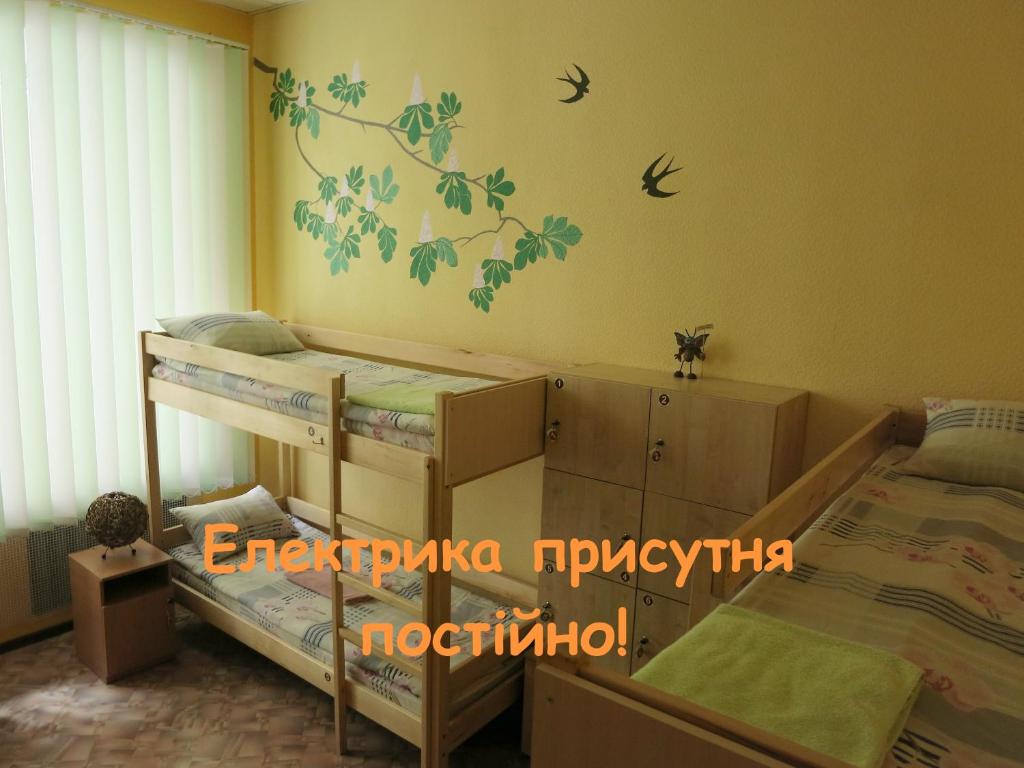 a bedroom with two bunk beds with birds on the wall at Hostel Delil in Kyiv