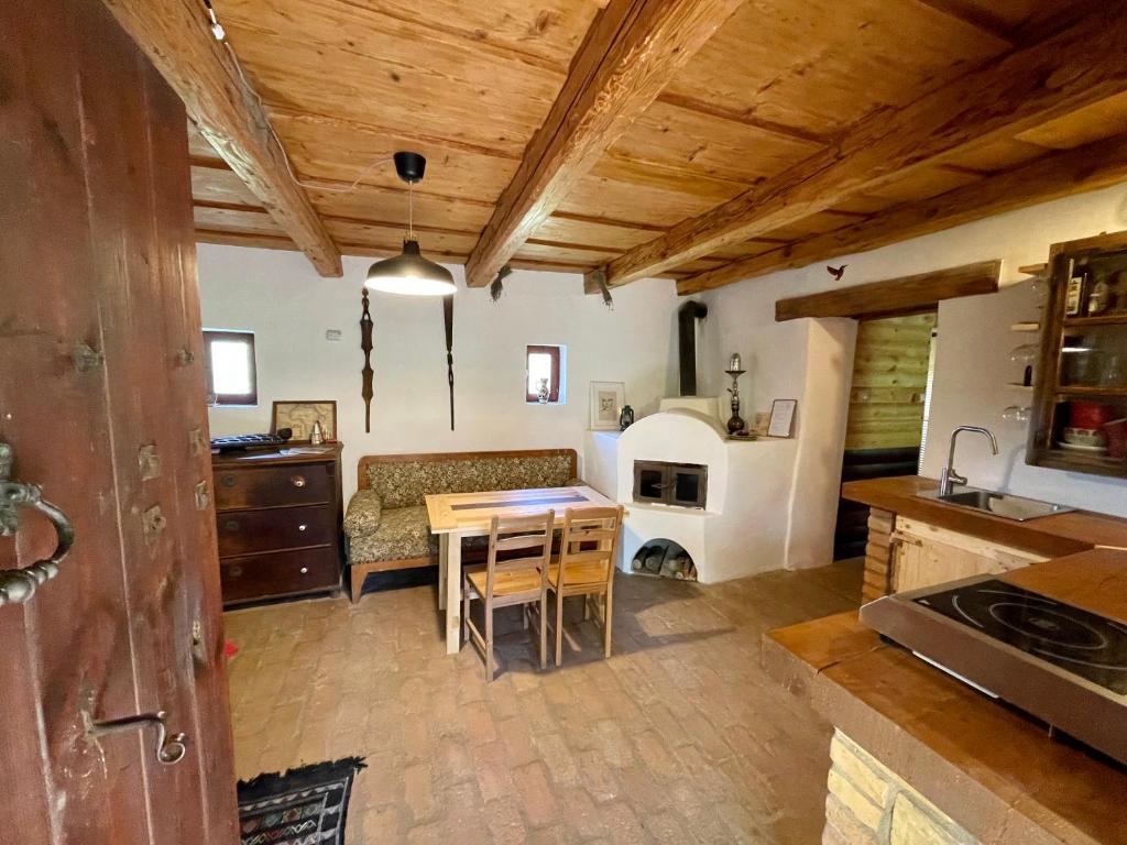 a kitchen and living room with a table and a couch at Nature Lodge Csesztve in Csesztve