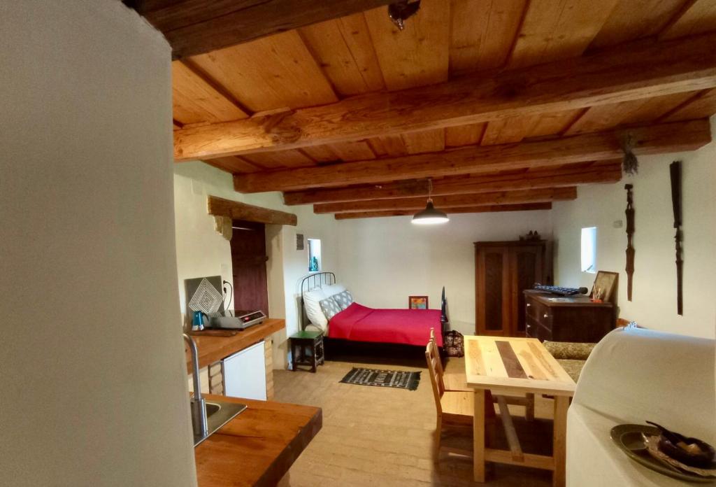 a living room with a red bed and a table at Nature Lodge Csesztve in Csesztve