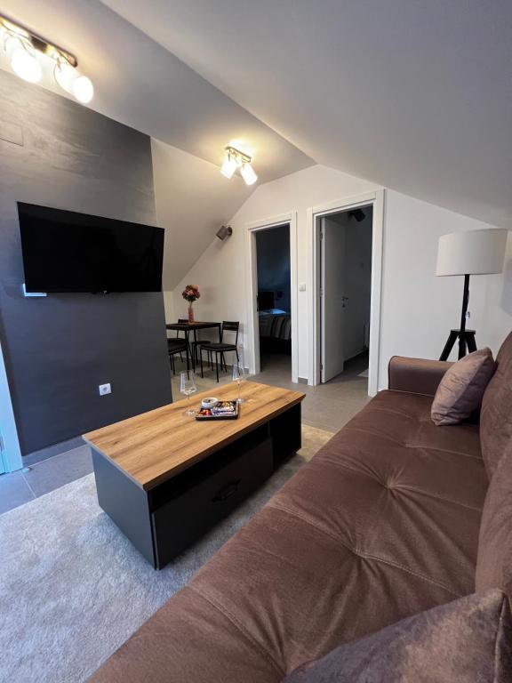 ein Wohnzimmer mit einem Sofa und einem Flachbild-TV in der Unterkunft Ortak Apartments in Belgrad