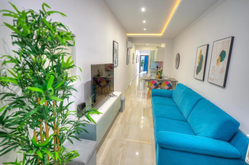 ein Wohnzimmer mit einem blauen Sofa und einigen Pflanzen in der Unterkunft Modern and bright 2bedroom with terrace SARD1-1 in St Julian's