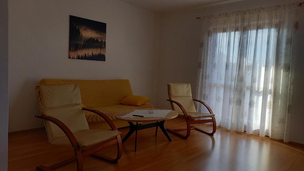 a living room with a couch and chairs and a table at Apartmani Danica in Biograd na Moru