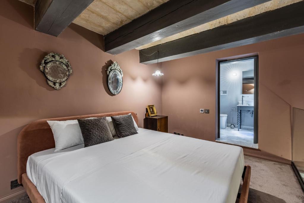 um quarto com uma grande cama branca num quarto em House of W em Valletta