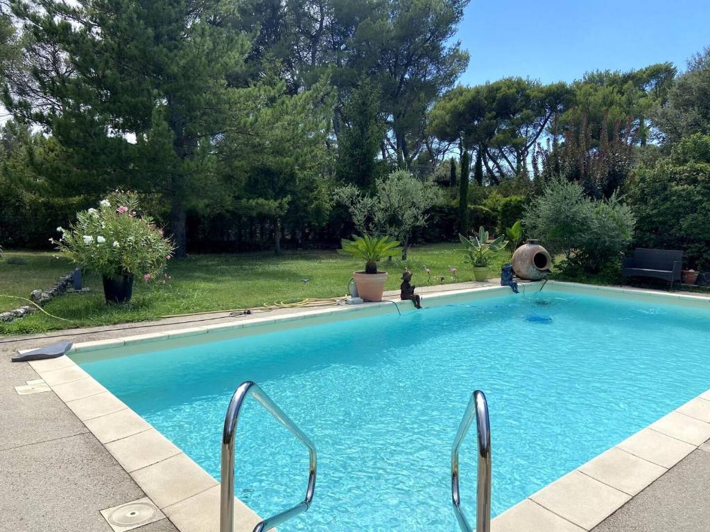 una gran piscina azul en un patio en Les Lauriers en Lubéron, en Cheval Blanc