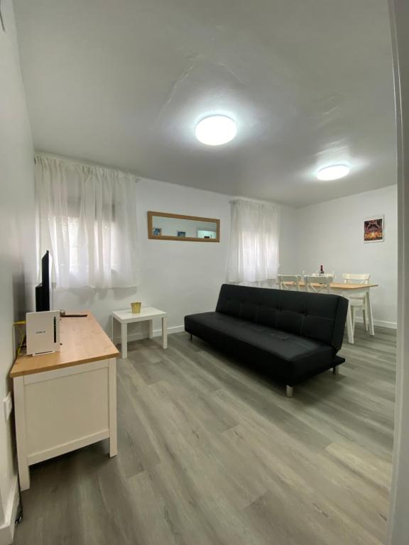 sala de estar con sofá negro y mesa en piso junto al hospital macarena en Sevilla