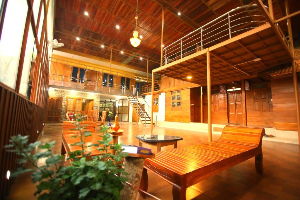 Habitación grande con bancos de madera en un edificio en AYURGREEN HERITAGE, en Kattappana