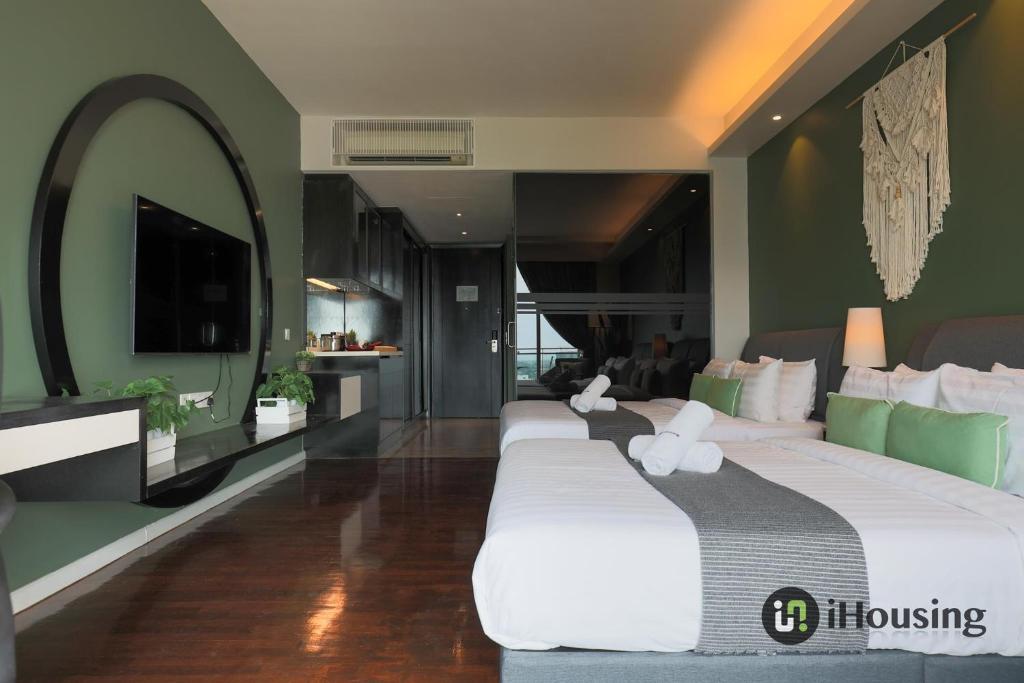 zwei Betten in einem Zimmer mit grünen Wänden in der Unterkunft The Shore Premium Melaka By I Housing in Malakka