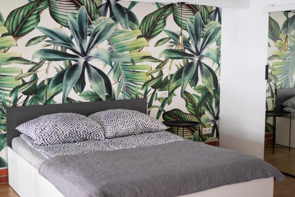 1 dormitorio con 1 cama con un mural de palmeras en RedCity LOFT 303, en Żyrardów