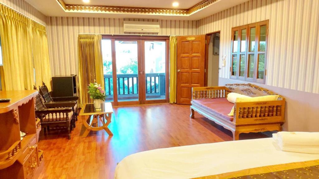 a bedroom with a bed and a desk and a television at Raya Ville in Amphoe Koksamui