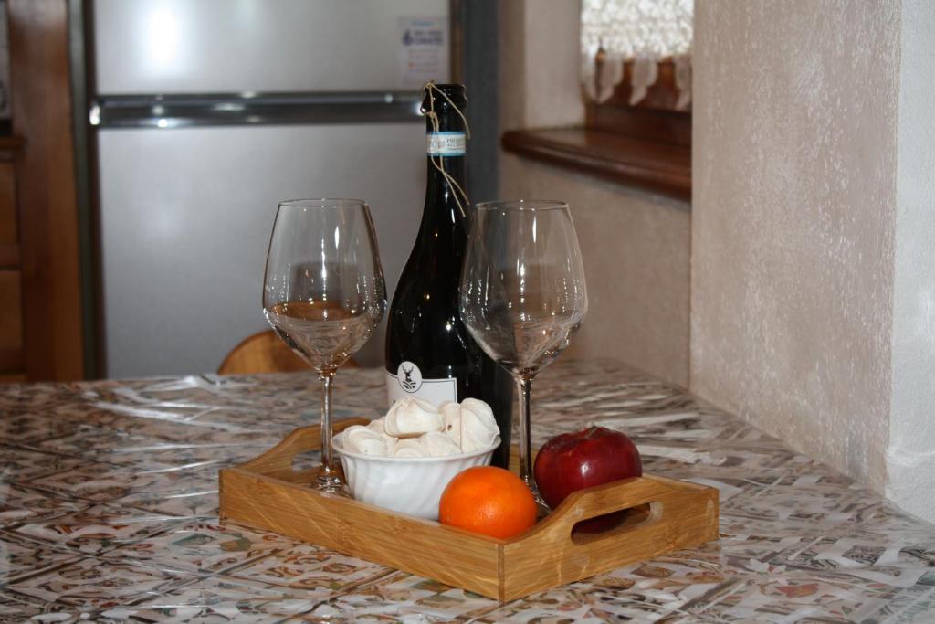 a table with two glasses and a bottle of wine at Casa Longa in Livigno