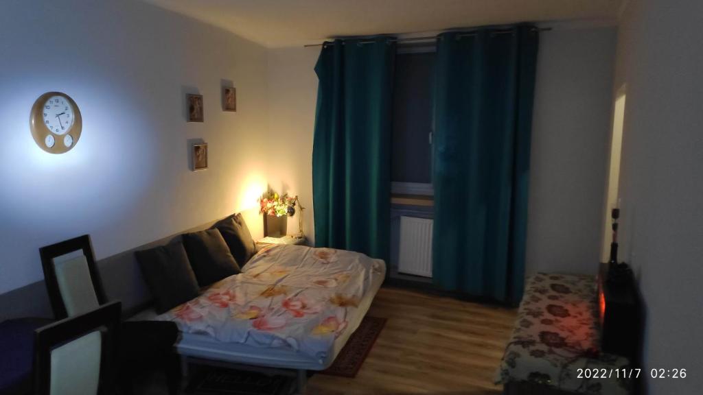 a bedroom with a bed in a room with blue curtains at Studio Matejki 29, BYTOM in Bytom