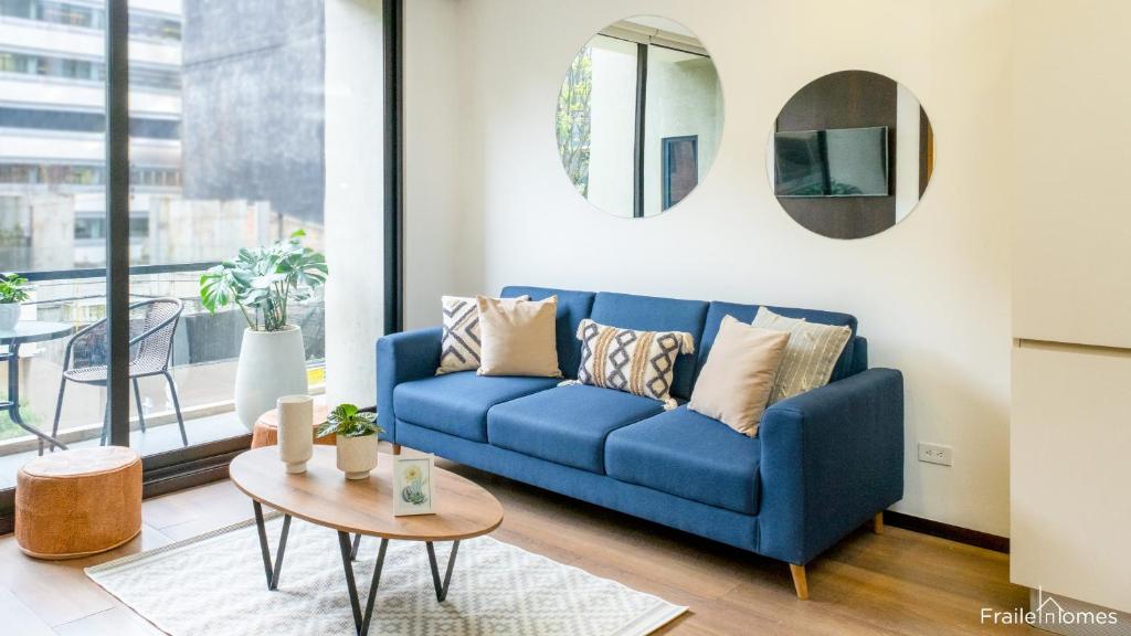 Sofá azul en la sala de estar con mesa en FH - Stunning apartment in Chico, en Bogotá