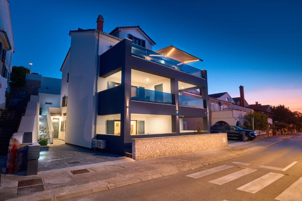 un gran edificio blanco con luces en la parte superior en House Torre Apartments en Mali Lošinj