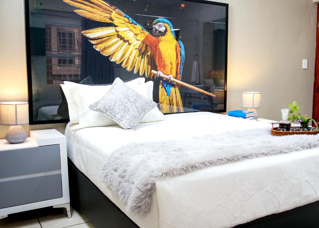 - une chambre avec un mur orné d'un perroquet dans l'établissement Jose Guesthouse, à Kempton Park