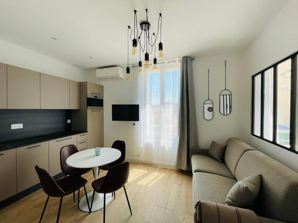 un salon avec un canapé, une table et des chaises dans l'établissement Deux pièces Neuf TURCKHEIM TUR201, à Cannes