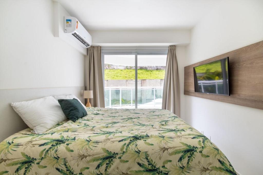 1 dormitorio con cama y ventana en Qavi - Flat em Resort Beira Mar Cotovelo #InMare109 en Parnamirim