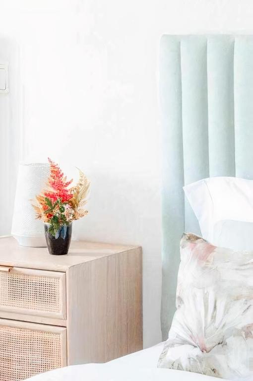 a bedroom with a bed and a table with a plant on it at Casa Bela Vista de Moledo in Moledo